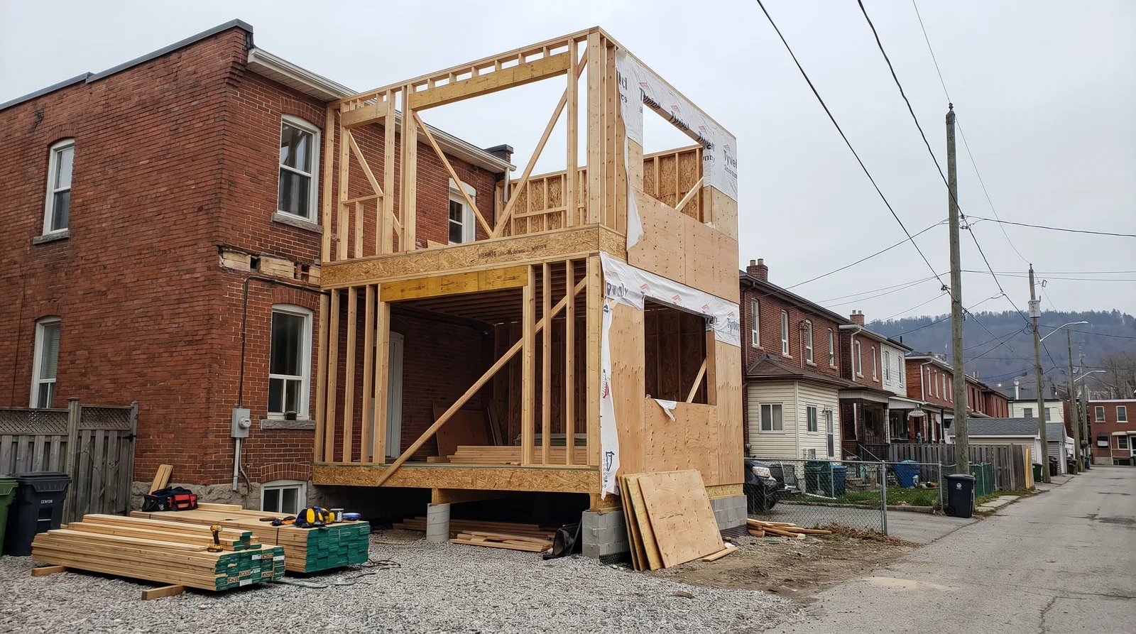Two-storey rear addition under construction on a Hamilton brick home with the escarpment beyond